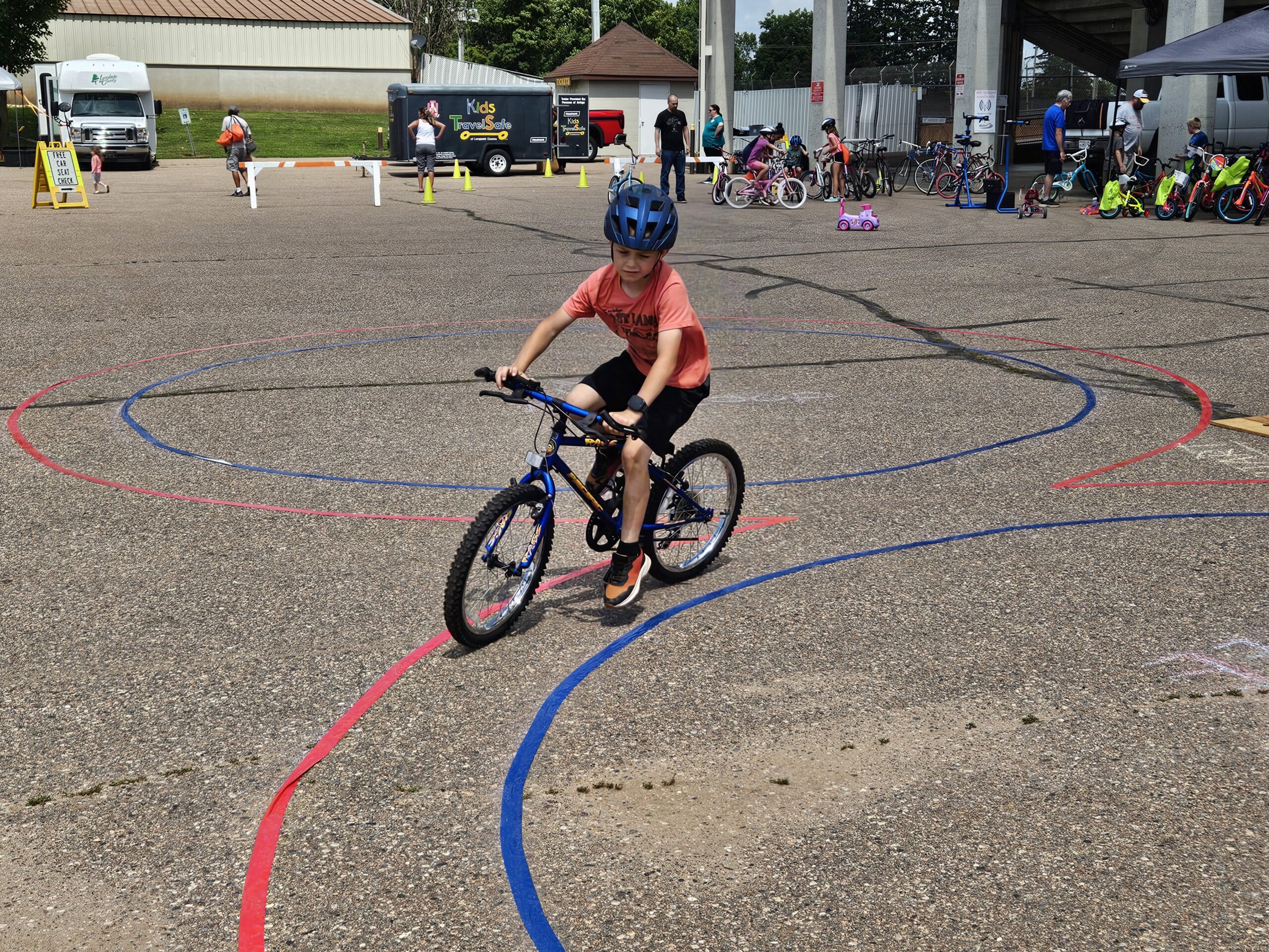 child riding a two-wheel bike on a course at the bike rodeo